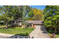 Charming single-story home features a brick facade, lush lawn, mature trees, and a two car garage at 255 Kiowa Pl, Boulder, CO 80303