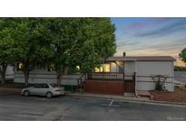 Charming single story home featuring a cozy front deck and mature trees at 8509 Colorado Ct, Denver, CO 80229