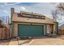 Charming home featuring a two-car garage, brick accents, dormer windows, and well-maintained landscaping at 6758 W Louisiana Pl, Lakewood, CO 80232