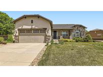 Charming single Gathering home featuring stone accents, a two-car garage, and a well-manicured lawn at 16550 Antero Cir, Broomfield, CO 80023