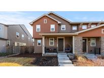 Charming two-story home featuring a cozy front porch with stylish decor and manicured landscaping at 11420 E 26Th Ave, Aurora, CO 80010