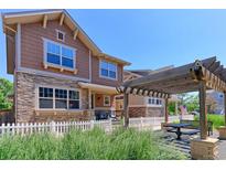 Inviting exterior view showcasing a two-story home with stone accents and outdoor dining area at 13713 Raritan Ln, Broomfield, CO 80023