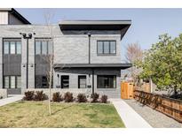 Stylish gray brick home featuring modern design, black trim, and well-maintained landscaping at 3927 N Cook St, Denver, CO 80205