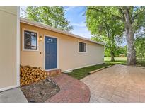 Charming home exterior featuring a blue front door, brick walkway, and manicured landscaping at 6396 Twin Lakes Rd, Boulder, CO 80301