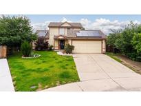 Inviting two-story home with a well-manicured lawn, complemented by solar panels and an attached two-car garage at 9563 Milwaukee Ct, Thornton, CO 80229