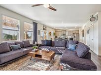 Open living room with sectional sofa and kitchen view at 803 William Way, Brighton, CO 80603