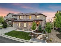 Stunning home featuring meticulous stone work, a tile roof, and a professionally landscaped front yard at 10757 Timberdash Ave, Highlands Ranch, CO 80126