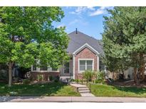 Charming brick home with mature trees, landscaped yard, and inviting front entrance at 1011 S Valentia St # 3, Denver, CO 80247