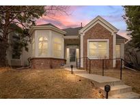 Charming single-Gathering home featuring brick accents and a well-maintained front yard at sunset at 1011 S Valentia St # 3, Denver, CO 80247