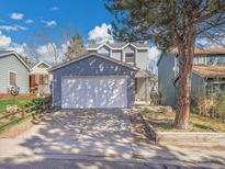 Charming two-story home featuring an attached two-car garage and a well-maintained front yard at 8047 Lee Ct, Arvada, CO 80005