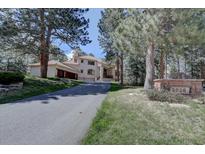 Inviting two-story home with a long driveway and beautiful mature trees at 2828 Keystone Dr, Evergreen, CO 80439