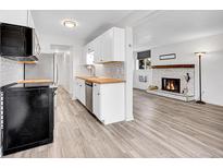Bright kitchen with white cabinets, butcher block counters, stainless steel appliances, and modern backsplash at 17505 E Mansfield Ave # 1412R, Aurora, CO 80013
