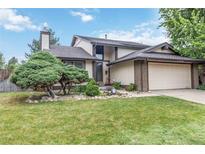 Charming two-story home with an attached garage, lush lawn, and beautifully landscaped front yard at 3709 S Fairplay Way, Aurora, CO 80014