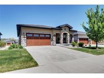 Charming home featuring stone accents, a spacious garage, and a well-manicured lawn at 365 Casalon Pl, Superior, CO 80027
