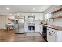 Bright kitchen featuring white cabinets, butcher block counters, and stainless steel appliances at 5320 W 13Th Ave, Lakewood, CO 80214