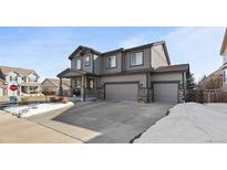 Charming two-story home showcasing a spacious driveway and a well-maintained landscaped yard with stone details at 8104 El Jebel Loop, Castle Rock, CO 80108