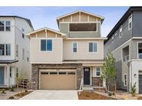 Beautiful multi-story home featuring mixed siding and stone accents, a two-car garage, and a covered patio at 8245 Butte Creek St, Littleton, CO 80125