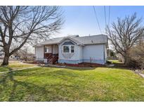 Charming home with a covered porch and inviting lawn at 5990 W 8Th Ave, Lakewood, CO 80214