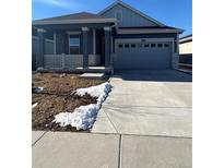 Ranch style home with gray exterior, attached garage, and landscaping at 5127 N Quemoy St, Aurora, CO 80019