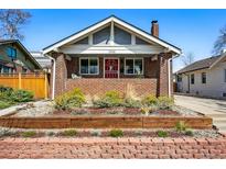 Charming brick home featuring a manicured front yard and a welcoming red front door at 3345 W Clyde Pl, Denver, CO 80211