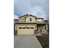 Charming two-story home with a two-car garage and manicured front lawn and covered porch at 10611 Casper St, Parker, CO 80134