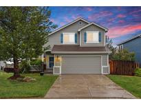 Charming two-story home with a well-manicured lawn, gray siding, and a two-car garage at 7888 Canvasback Cir, Littleton, CO 80125