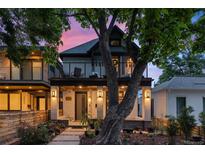 Charming home with a welcoming front porch, elegant columns, and a lush landscaped yard during a beautiful sunset at 3410 Pecos St, Denver, CO 80211