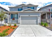 Charming two-story home featuring a two-car garage, manicured lawn, and inviting front porch with blue shutters at 4505 Cholla Trl, Castle Rock, CO 80104