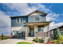 Charming two-story home with a covered porch and stone accents, creating a welcoming curb appeal at 13794 Honey Hush Trl, Parker, CO 80134
