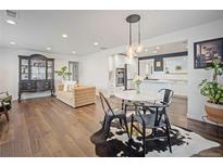 Bright living room showcases wood floors, dining area, and open access to a modern kitchen at 407 S Ingalls St, Lakewood, CO 80226