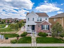 Charming two-story home with a welcoming front porch, lush lawn and beautiful landscaping at 21682 E Stroll Ave, Parker, CO 80138
