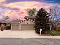 Charming brick home featuring a three-car garage and well-maintained landscaping at 13031 Dexter St, Thornton, CO 80241
