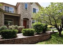 Inviting two-story home boasts a stone facade, manicured landscaping, and a charming red front door at 4500 E Louisiana Ave, Denver, CO 80246
