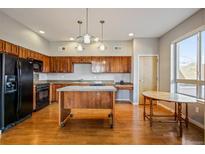 Bright kitchen featuring wood cabinets, granite counters, stainless steel appliances and a center island at 1057 W Century Dr # 112, Louisville, CO 80027