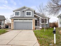 Two-story home with stone accents, gray siding, and a two-car garage in a well-maintained neighborhood at 4010 E 129Th Way, Thornton, CO 80241