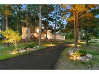 Inviting front of home with landscaped driveway and well-lit exterior at 18971 Shadowood Dr, Monument, CO 80132