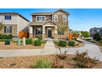 Charming two-story home features a stone facade, covered porch, and well-manicured landscaping at 6833 Longpark Dr, Parker, CO 80138