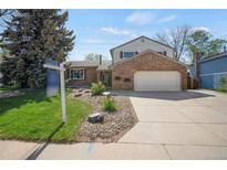 Charming two-story home with brick facade, attached garage, and well-maintained front yard at 9386 W Geddes Pl, Littleton, CO 80128