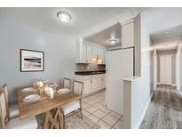 Open concept kitchen and dining area with white cabinets and sleek black countertops at 451 Golden Cir # 210, Golden, CO 80401