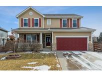 Charming two-story home boasts a red garage door and complementary red shutters at 13850 Meadowbrook Dr, Broomfield, CO 80020