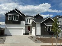 New construction, two-story home showcasing white and dark siding, with a two-car garage and well-manicured landscaping at 16521 Black Rose Cir, Parker, CO 80134