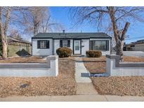 Charming home with white siding, black shutters, and a well-maintained front yard at 1100 Hillside St, Aurora, CO 80010