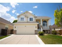 Charming two-story home with a two-car garage, lush lawn and inviting front porch at 245 Homestead Way, Brighton, CO 80601