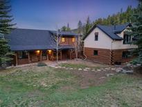 Charming log home featuring a covered porch and beautiful landscaping at 24 Pine Valley Rd, Evergreen, CO 80439