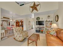 Inviting living room with a large star decor piece, cozy seating, and an open floorplan to the kitchen at 2804 S Heather Gardens Way # A, Aurora, CO 80014