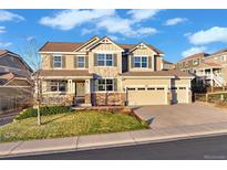 Charming two-story home boasts a three-car garage, manicured lawn, and inviting front porch at 2090 Bellavista St, Castle Rock, CO 80109