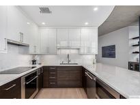 Modern kitchen featuring sleek white and wood cabinets, marble countertops, and stainless steel appliances at 1700 Bassett St # 1014, Denver, CO 80202