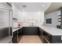 Modern kitchen featuring two-tone cabinets, stainless steel appliances, and hardwood floors at 1700 Bassett St # 1014, Denver, CO 80202