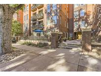 Brick condo building with updated entrance and well-maintained landscaping at 1630 N Clarkson St # 204, Denver, CO 80218