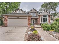 Charming two-story home with brick accents, a two-car garage, and beautiful landscaping at 19098 E Ida Dr, Aurora, CO 80015